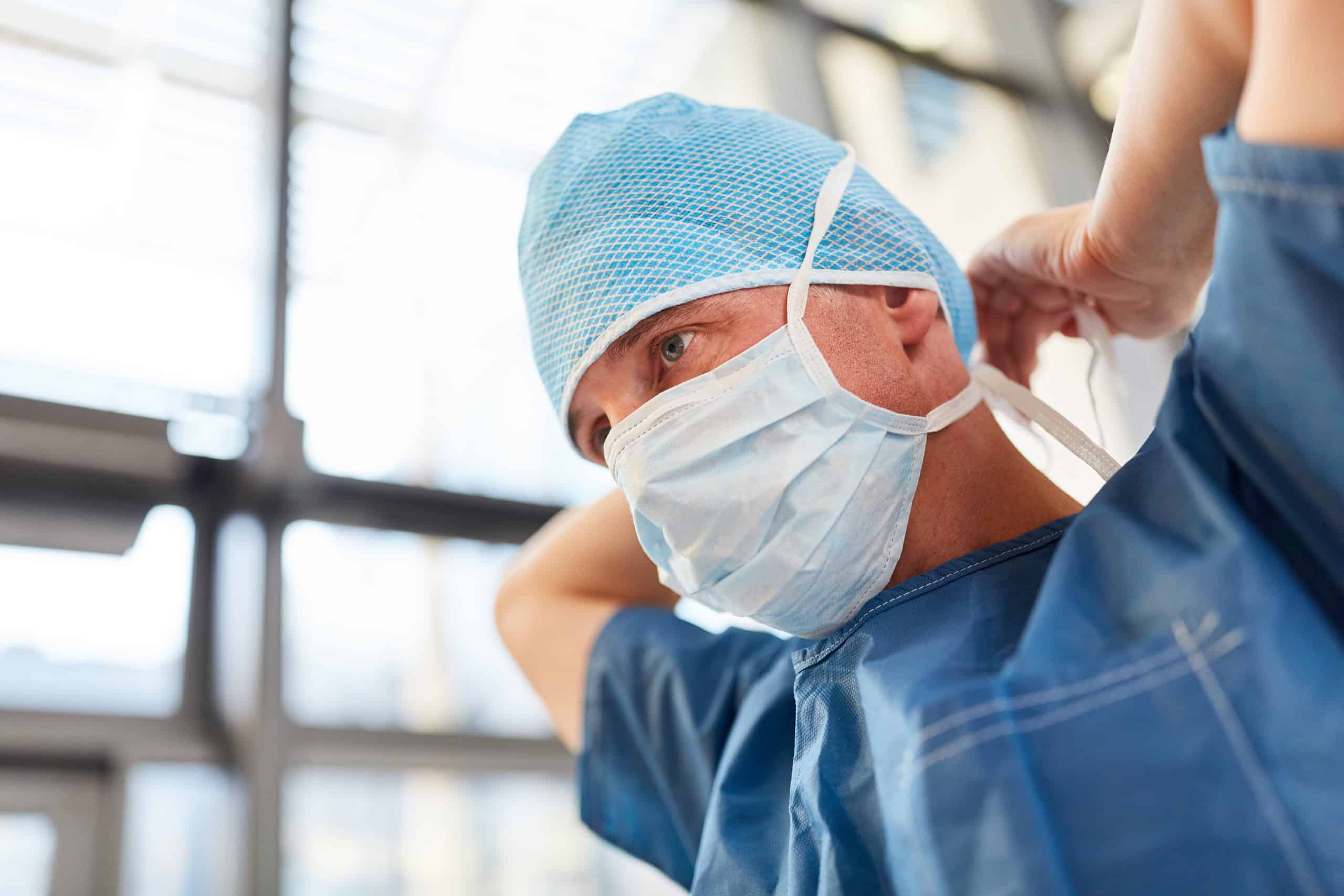 Un chirurgien en blouse bleue attache le protège-dents en cas d'urgence.